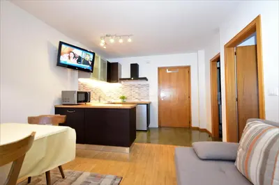 a kitchen and a living room with a table at Residence Albierch in Ortisei