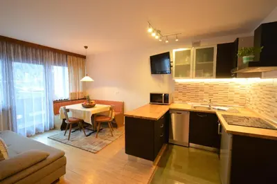 a kitchen and living room with a table and a couch at Residence Albierch in Ortisei