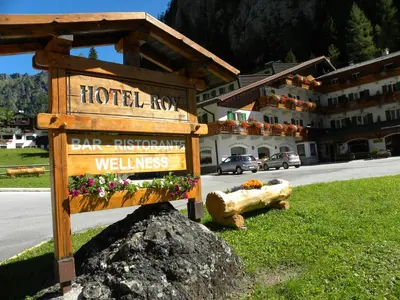 a sign in front of a hotel with a building at Hotel Roy in Malga Ciapela
