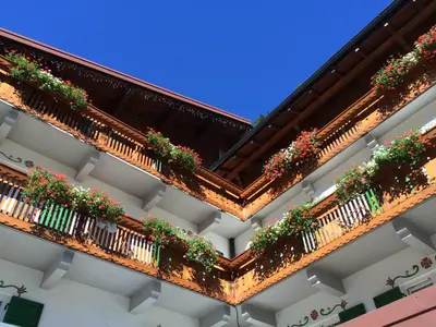 an apartment building with potted plants on the balconies at Hotel Roy in Malga Ciapela