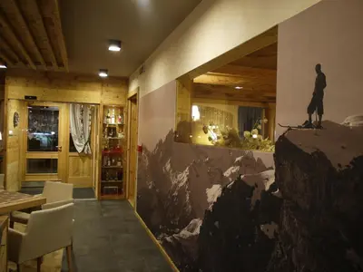 a dining room with a mural of a man on a mountain at Hotel Roy in Malga Ciapela