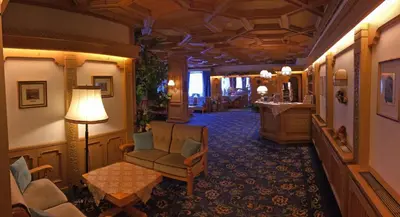 a hotel lobby with a chair and a table at Hotel Roy in Malga Ciapela