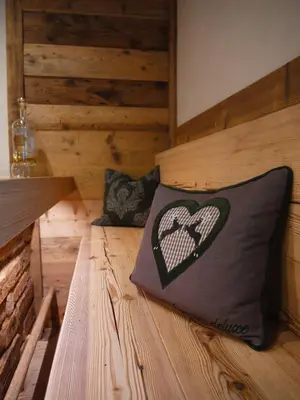a wooden bed with a pillow with a heart on it at Hotel Roy in Malga Ciapela