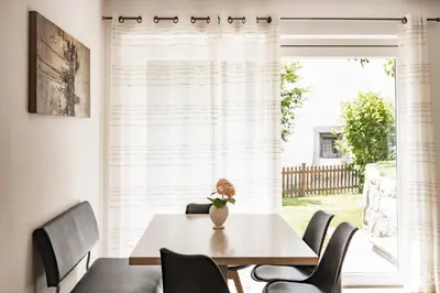 a dining room with a table and chairs and a window at Falgerhof in Vollan