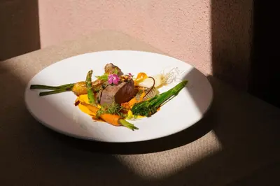 a white plate with food on a table at Vigilius Mountain Resort in Lana