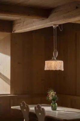 a room with a table with chairs and a light fixture at Vigilius Mountain Resort in Lana