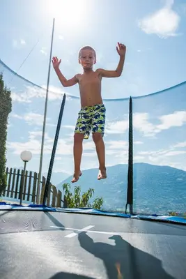 a young boy jumping on a trampoline at Garni Georgenhöhe in Schenna
