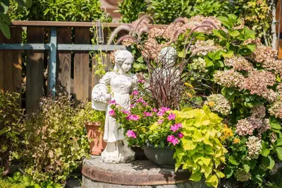 a statue of an angel in a garden with flowers at Garni Georgenhöhe in Schenna