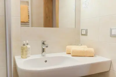 a bathroom with a white sink and a mirror at Garni Georgenhöhe in Schenna
