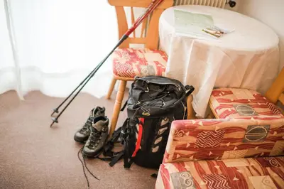 a room with a table and a bag and boots at Garni Georgenhöhe in Schenna