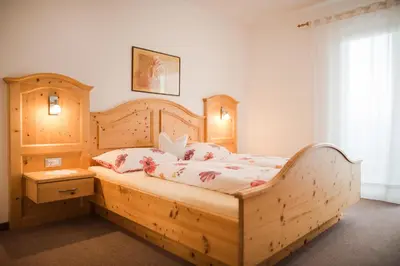 a bedroom with a wooden bed with a wooden frame at Garni Georgenhöhe in Schenna