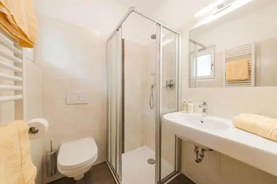 a bathroom with a shower and a sink and a toilet at Garni Georgenhöhe in Schenna