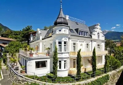 a large white house with a tower on top of it at Villa Maria in Tirolo