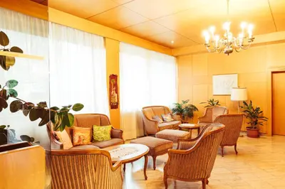 a living room with chairs and a table and a chandelier at Bio Hotel Kaufmann in Ora/Auer