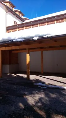 a large wooden structure in front of a building at Alpen Ferienwohnung II in Lappago