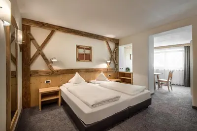 a bedroom with a large bed and a table at Hotel Gran Ciasa in Colfosco