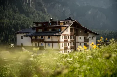 a house in the middle of a field of flowers at Hotel Gran Ciasa in Colfosco