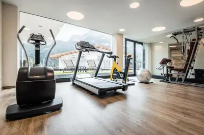a gym with treadmills and exercise equipment in a room at Hotel Gran Ciasa in Colfosco