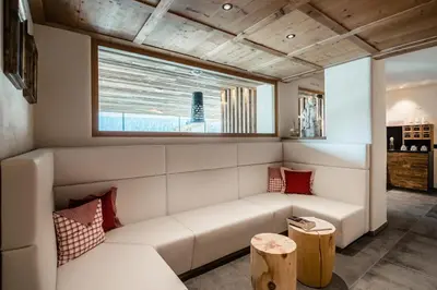 a living room with a white couch and a window at Hotel Gran Ciasa in Colfosco