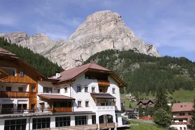 a hotel with a mountain in the background at Residence Vila in Colfosco