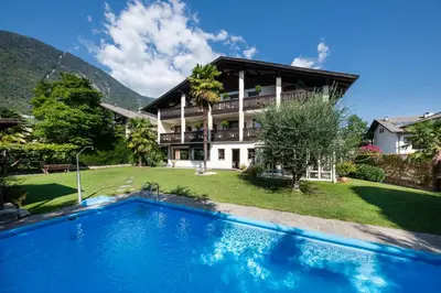 a house with a swimming pool in front of a house at Pension Weingarten in Lana