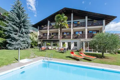 a large house with a swimming pool in front of it at Pension Weingarten in Lana