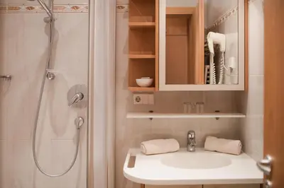 a bathroom with a white sink and a shower at Pension Weingarten in Lana