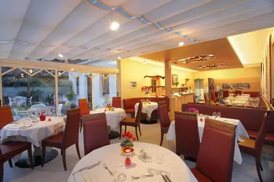 a dining room with tables and chairs and a restaurant at Pension Weingarten in Lana