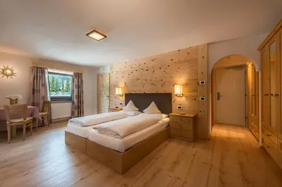 a bedroom with a large bed and a table at La Stua in San Cassiano