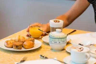 a table with a plate of food and a cup of orange juice at La Stua in San Cassiano