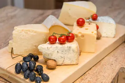 a wooden board with cheese and grapes and tomatoes at La Stua in San Cassiano