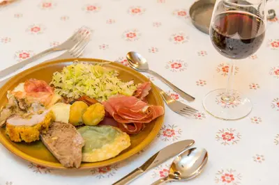 a plate of food on a table with a glass of wine at La Stua in San Cassiano