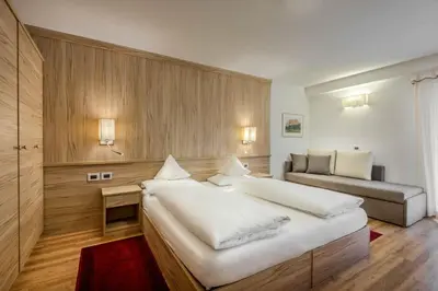 a bedroom with a large bed and a couch at La Stua in San Cassiano
