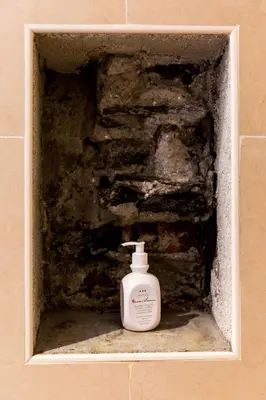 a bottle of soap in a niche in a wall at Hotel Weisses Lamm in Monguelfo