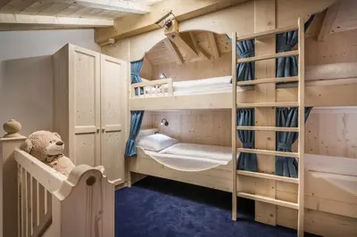 a bedroom with a four poster bed with curtains at Alpenhotel Plaza in Santa Cristina in Val Gardena