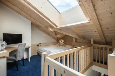 a room with a bed and a skylight at Alpenhotel Plaza in Santa Cristina in Val Gardena