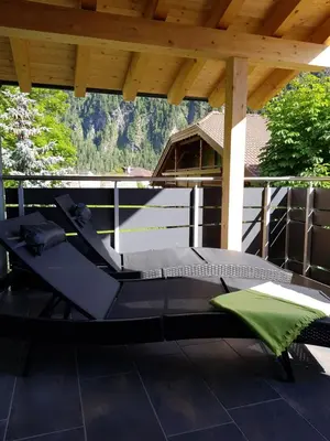 a patio with a table and chairs on a roof at Klimahouse North in Campitello di Fassa