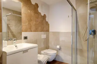 a bathroom with a toilet and a sink and a shower at Klimahouse North in Campitello di Fassa