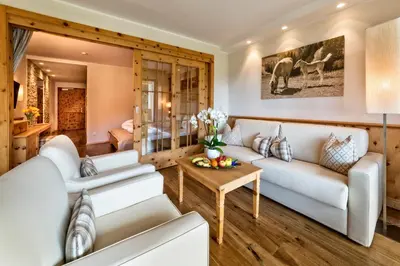 a living room with white couches and a table at Hotel Sulfner in Avelengo