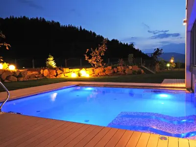 a swimming pool in a backyard at night at Hotel Sulfner in Avelengo