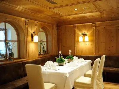 a dining room with a white table and chairs at Hotel Sulfner in Avelengo