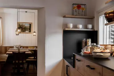 a kitchen with a table and a dining room at Garni Hotel Tauber in Bressanone