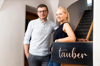 a man and a woman holding a sign that says laughter at Garni Hotel Tauber in Bressanone