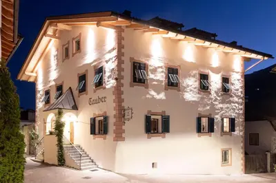 a large white building with black shutters at Garni Hotel Tauber in Bressanone