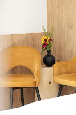 two chairs and a vase of flowers on a counter at Garni Hotel Tauber in Bressanone