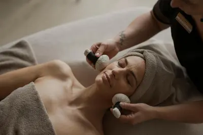 a woman laying on a bed getting her hair brushed at La Maiena Meran Resort in Marlengo