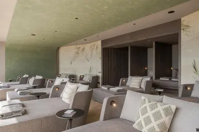 a waiting room with couches and tables at La Maiena Meran Resort in Marlengo