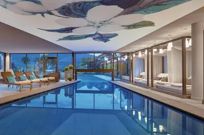 a swimming pool with a ceiling with a flower mural at La Maiena Meran Resort in Marlengo