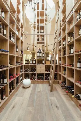 a room filled with shelves with wine bottles at La Maiena Meran Resort in Marlengo