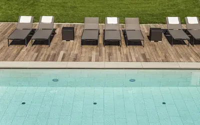 a group of chairs sitting next to a swimming pool at Hotel Petrus in Brunico